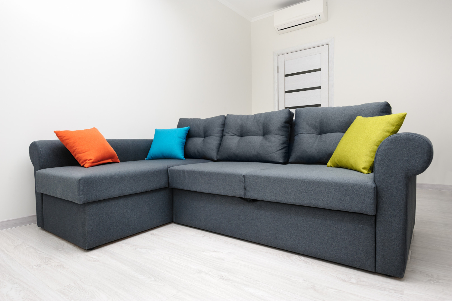 Modern grey L-shaped sectional sofa in a bright living room