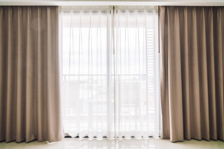 Neutral beige blackout curtains paired with white sheer panels